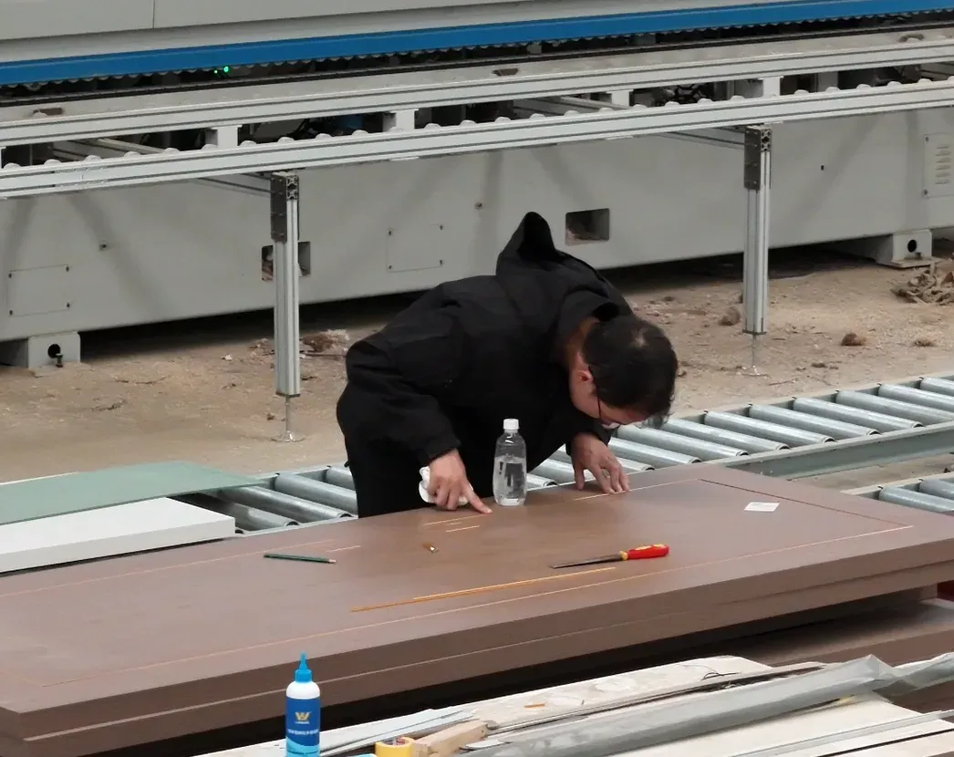 Worker inspecting details on a flush door at the ChanWood factory